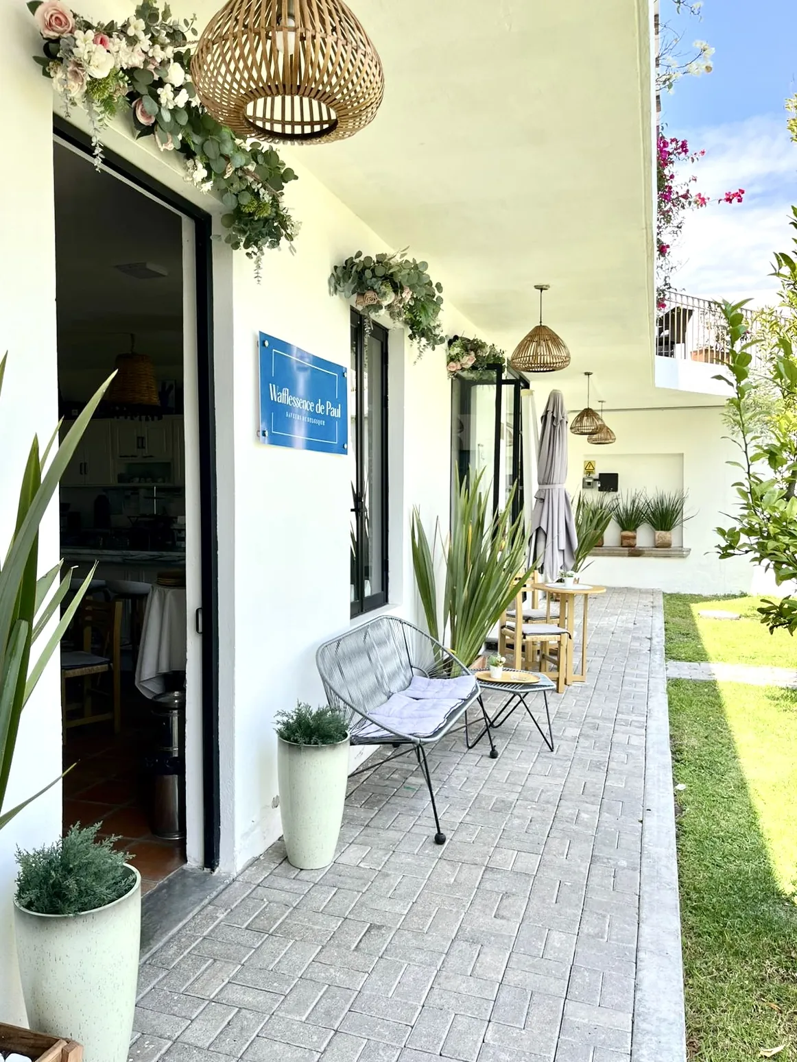 Terraza con puerta, plantas, mesa, sillas y lámparas